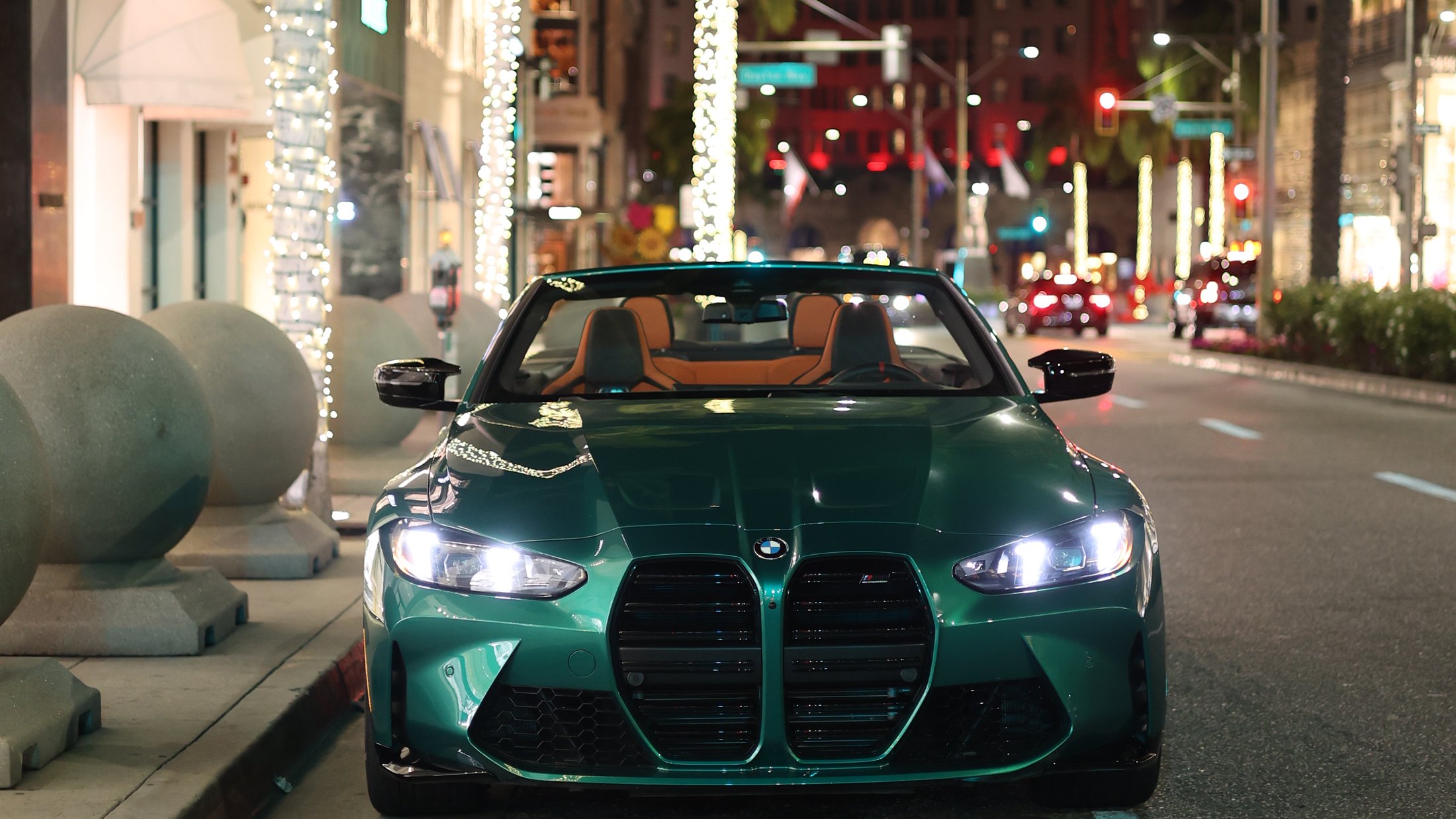 Green BMW M4 Competition convertible on Rodeo Drive at night